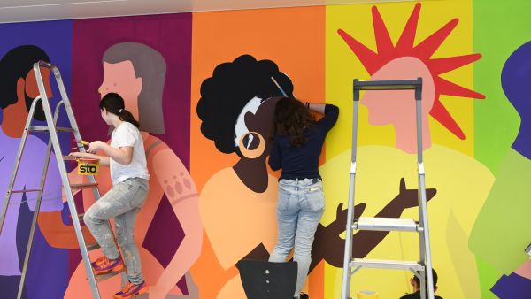 Zwei Lernende arbeiten an der Fertigstellung der neuen Wandgestaltung