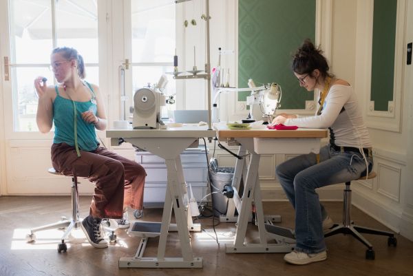 Die beiden Lernenden Jutta Rothenbühler und Matilda Losinger bei der Herstellung der Stoffblumen vor Ort